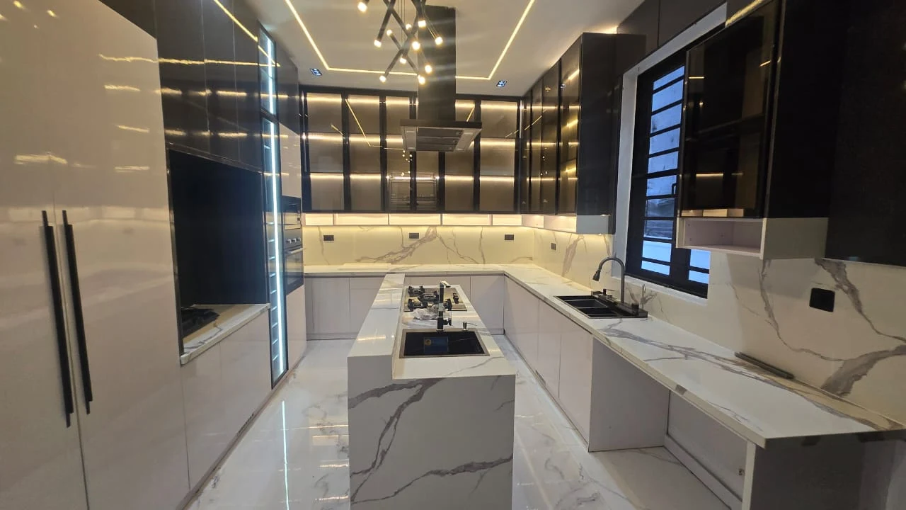 Contemporary kitchen with a central island, white cabinetry and illuminated display cabinets